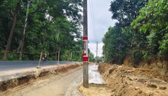 রাস্তার মাঝে বৈদ্যুতিক খুঁটি রেখেই চলছে নির্মাণকাজ